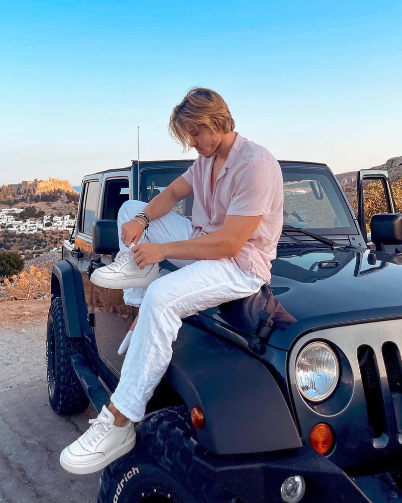 Dekel sitting on a Jeep at sunset